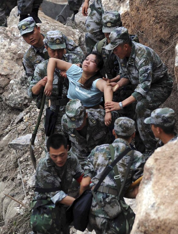 चीनमधील भूकंपात शिचुआना प्रांतातील मोठ्या प्रमाणावर पडझड झाली. मातीच्या ढीगाऱ्यात अडकलेल्या महिला बाहेर काढताना जवान