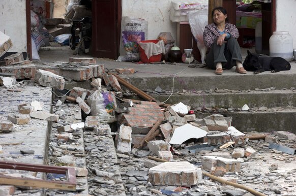 चीनमधील भूकंपाच्या तडाख्यात सापडलेले घर. घराची अशी अवस्था झाल्याने हतबल झालेली महिला.