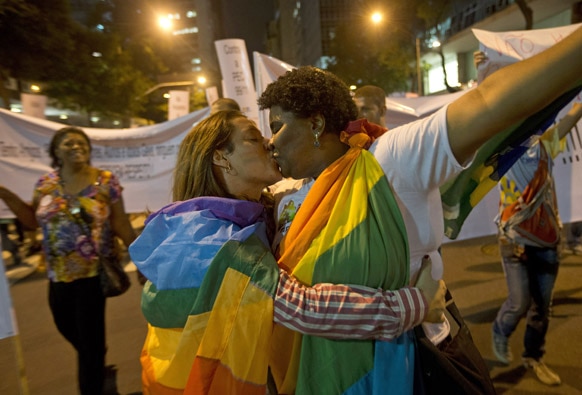 दोन समलिंगी झेंडा गुंडाळून होमो फोबियाचा निषेध करताना रियो दि जानेरो, ब्राझिलमध्ये