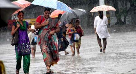 मुसळधार पाऊस कोसळत असल्याने पावसाचा सामना करताना महिला