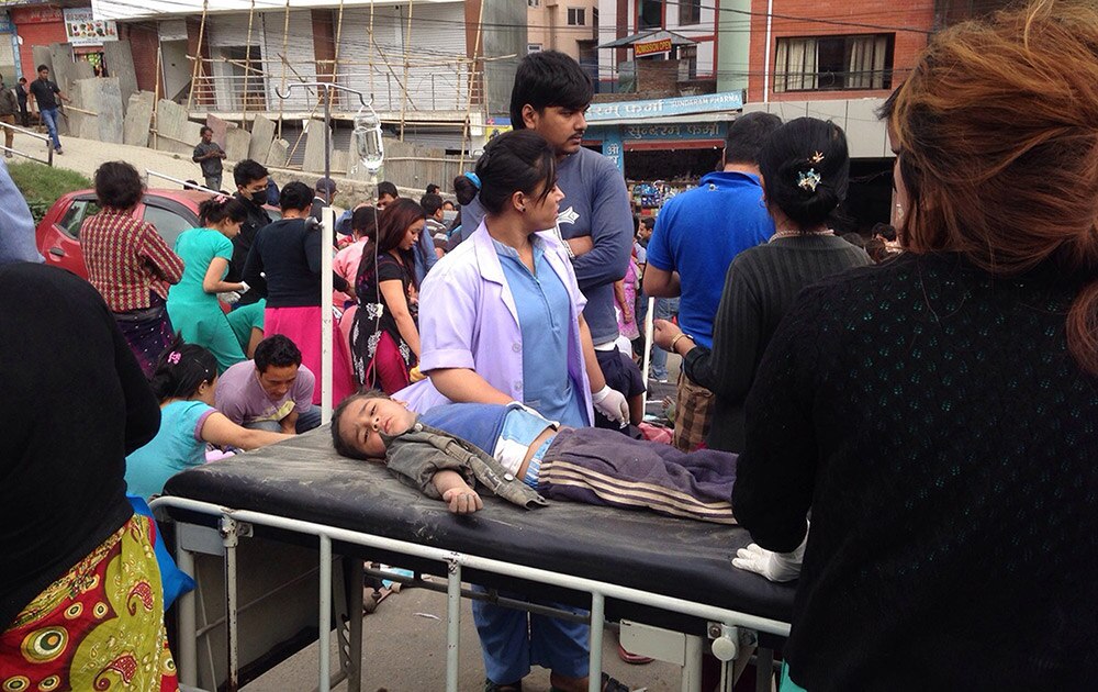 नेपाळ आज ७.९ रिश्टर स्केलच्या भूकंपाने हादरला. काठमांडू येथे भूकंपानंतर रस्त्यावर एका चिमुकल्यावर उपचार करताना डॉक्टर
