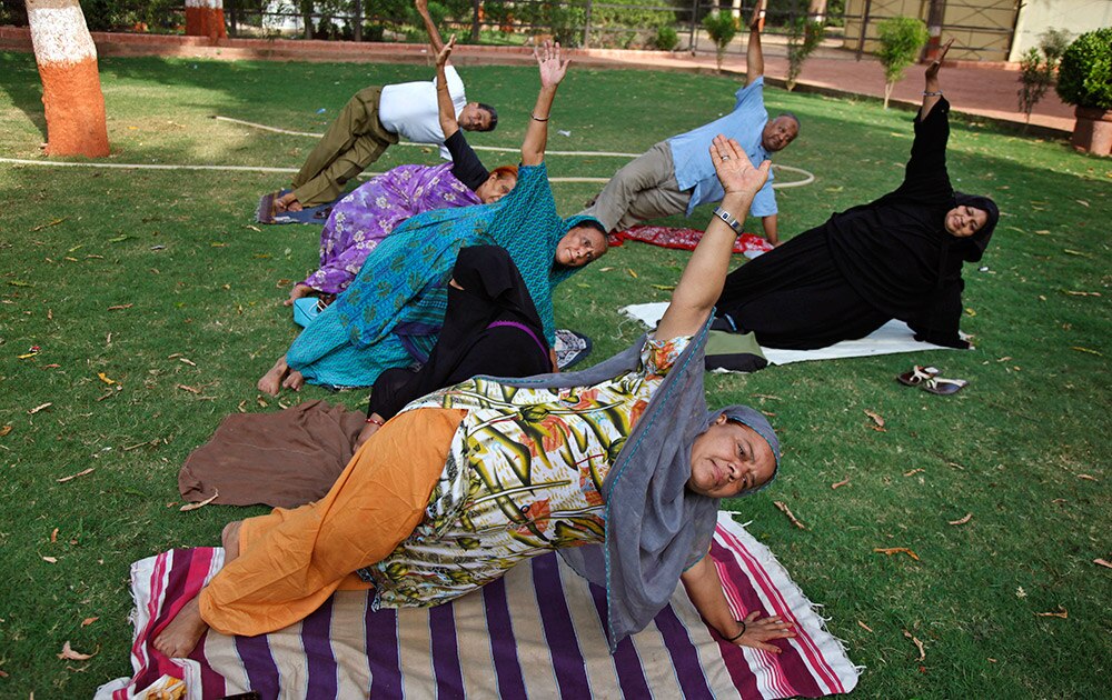 आंतरराष्ट्रीय योगदिन! - People perform Yoga exercises at a garden in Ahmadabad.
