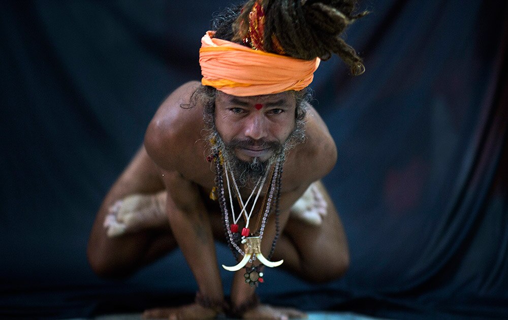 आंतरराष्ट्रीय योगदिन! Hindu holy man, illustrates the yoga pose Kakasana, or the crow pose in Guwahati.
