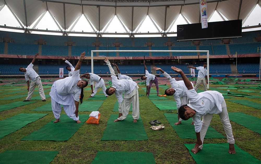 आंतरराष्ट्रीय योगदिन! People perform yoga in a stadium in New Delhi.
