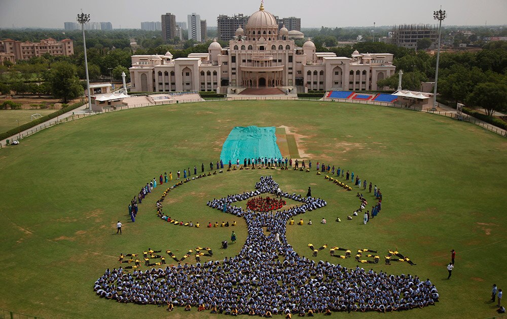 आंतरराष्ट्रीय योगदिन! Students make a formation of the International Yoga Day symbol at a school in Ahmadabad. Sunday, June 21, marks the first International Yoga Day, which the government of Prime Minister Narendra Modi is marking with a massive outdoor New Delhi gathering.

