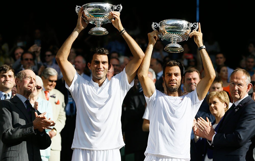 HORIA TECAU OF ROMANIA, LEFT, AND JEAN-JULIEN ROJER OF THE NETHERLANDS LIFT THE TROPHIES AFTER WINNING THE MEN'S DOUBLES FINAL
