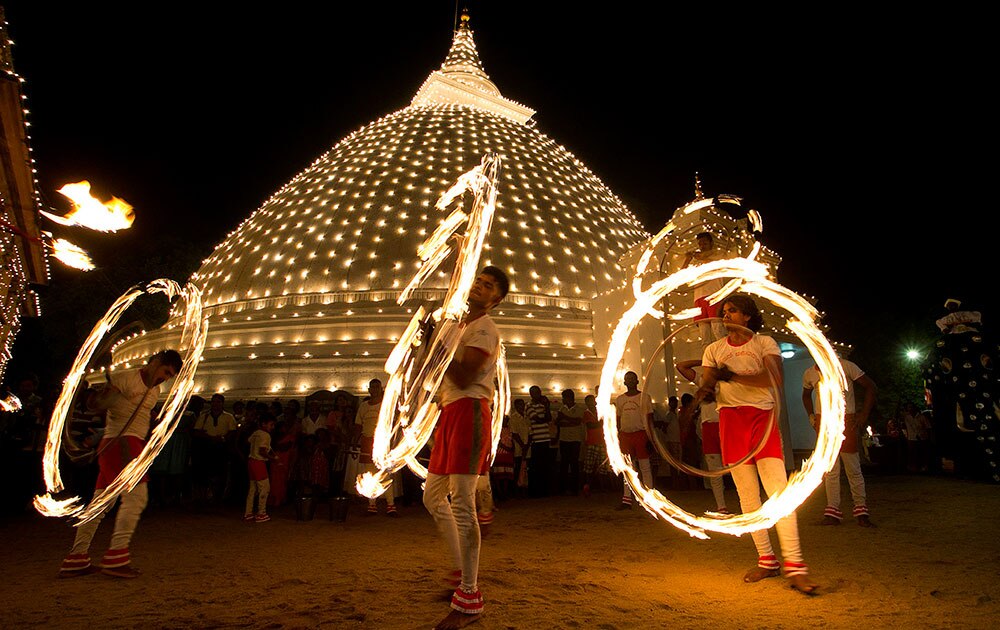 श्रीलंकेच्या कोलंबो येथील केलानी बौद्ध मंदिरात दुरुथू पेराहारा उत्सवात आगीशी खेळ करणारे साहसी कलाकार
