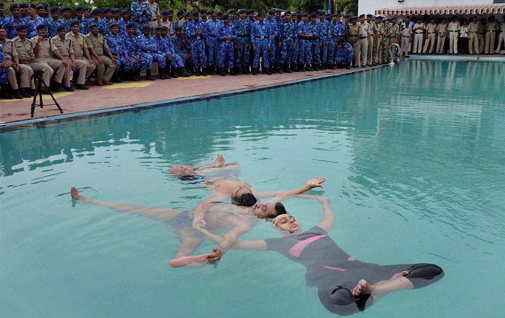 Members of Madhya Pradesh Backward Class Commission Laxmi Narayan Yadav with his nephew Yash and niece Tanvi performs Jal Yoga on the eve of International Day of Yoga, at a swimming pool in Bhopal.
