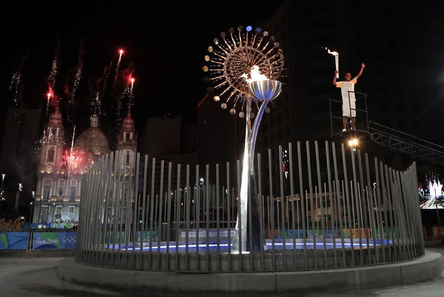 Jorge Alberto Oliveira Gomes reacts after lighting the Olympic cauldron