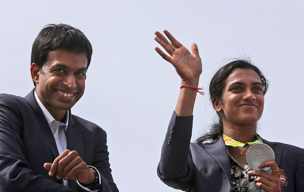 Pusarla Sindhu displays her silver medal as she is brought home in a procession along with her coach Pullela Gopichand