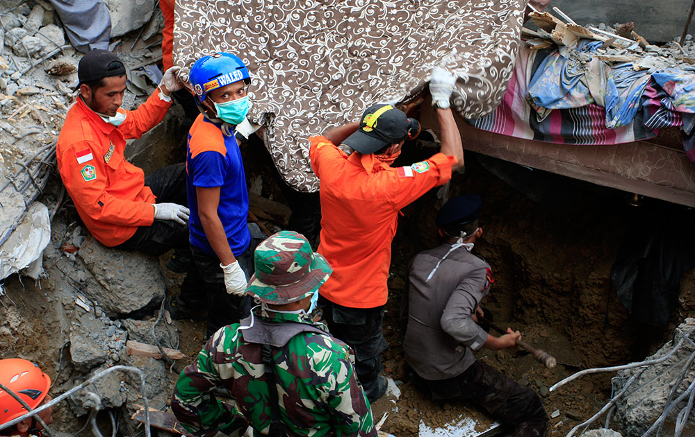 Indonesian army and the Search and Rescue Team look for survivors amongst the rubble