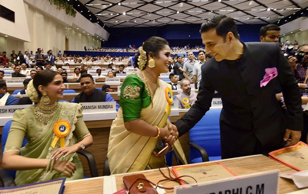 Best Actor award winner Akshay Kumar shakes hands with Best actress award winner Surabhi Jyoti at the 64th National Film Awards function