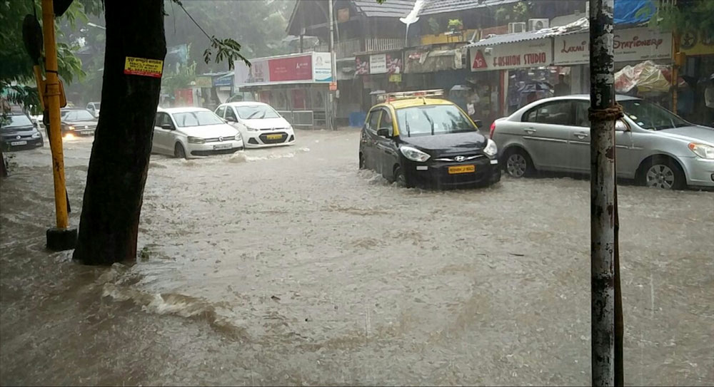 Vehicles struggle through a water-logged street