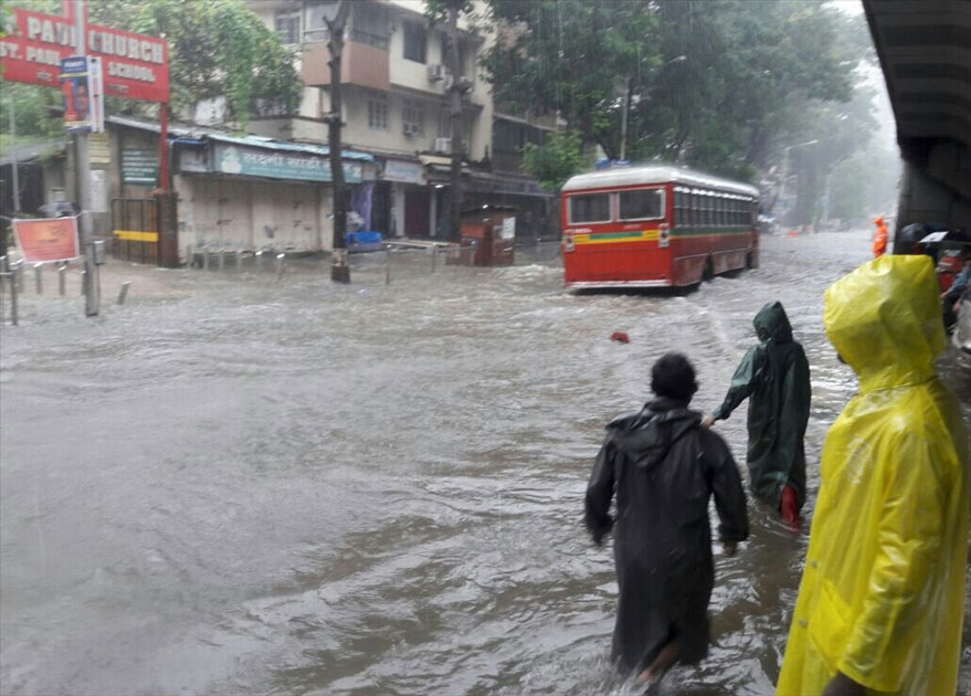 A bus struggles through a water-logged street