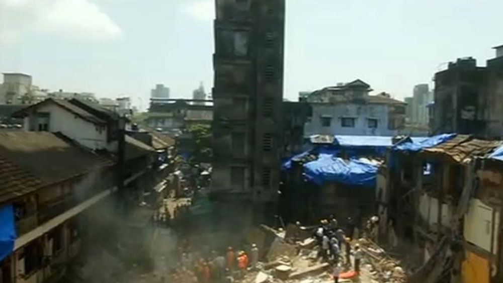 Personnel are seen after a building collapsed in Mumbai