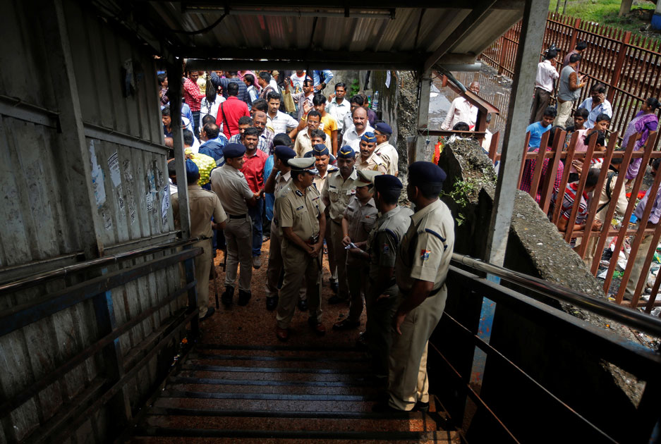 Policemen inspect the site of a stampede at a railway station`s pedestrian overbridge in Mumbai.