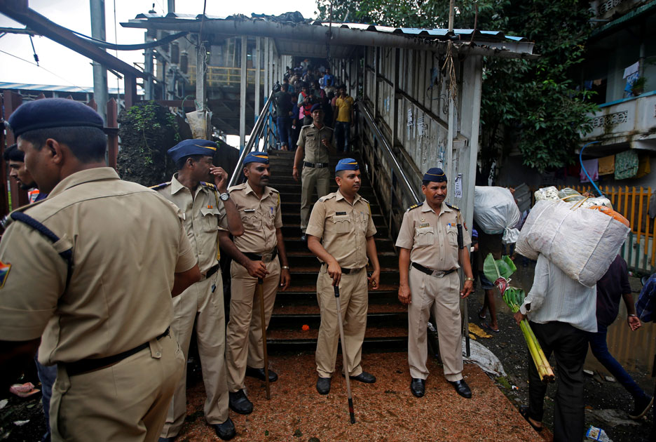 Policemen inspect the site of a stampede at a railway station`s pedestrian overbridge in Mumbai.