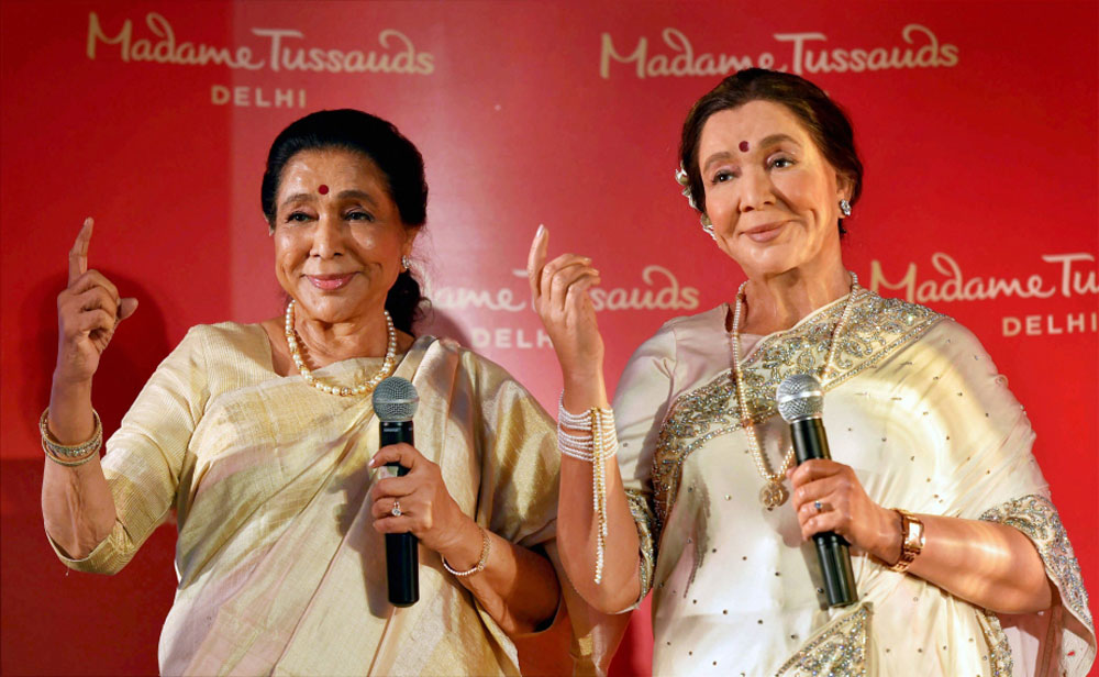 Legendary singer Asha Bhosle poses with her wax-statue during its unveiling, in New Delhi.