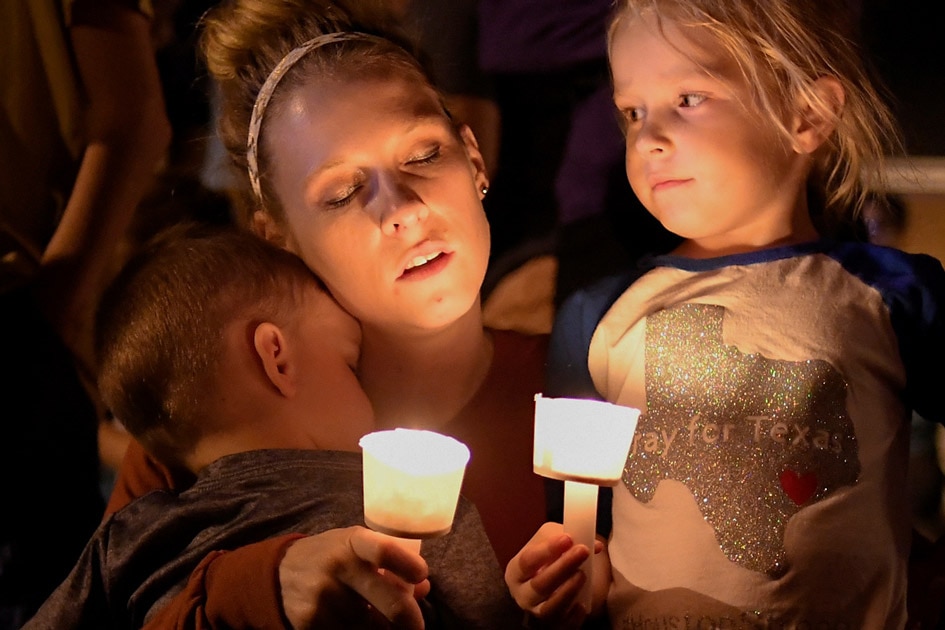 A woman and her children take part in a vigil for victims of a mass shooting in Sutherland Springs, Texas.