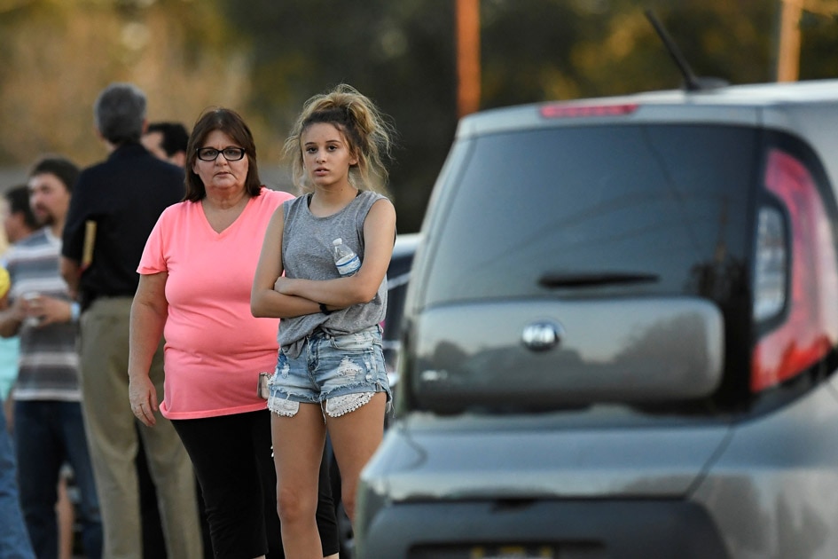 Local residents gather outside the Sutherland Springs Community Building after a mass shooting in Texas.