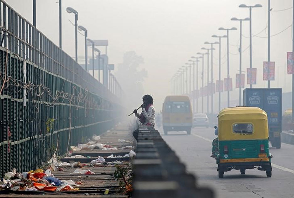 Man chews sugarcane on a bridge during smoggy morning in New Delhi.