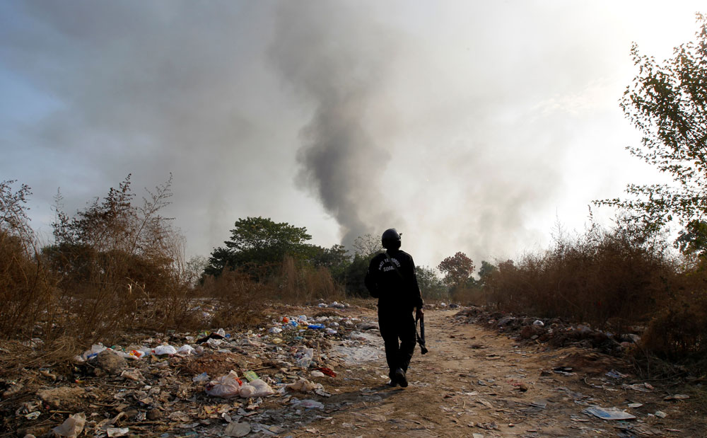 A policeman walks towards clashes with demonstrators near the Faizabad junction in Islamabad.