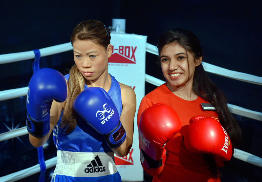 A volunteer poses with the wax figure of Boxing legend Mary Kom which was displayed at Madame Tussauds Wax Museum, during a press preview in New Delhi.