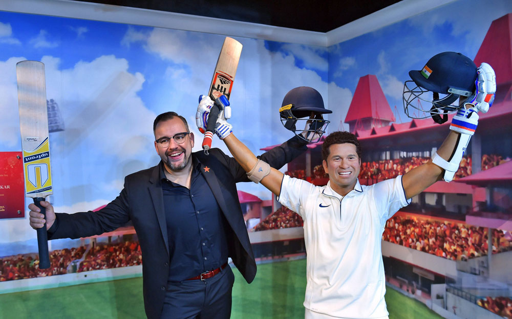 Merlin Entertainments’ director of new openings in emerging markets, poses with the wax figure of Sachin Tendulkar which was displayed at Madame Tussauds Wax Museum, during a press preview in New Delhi.