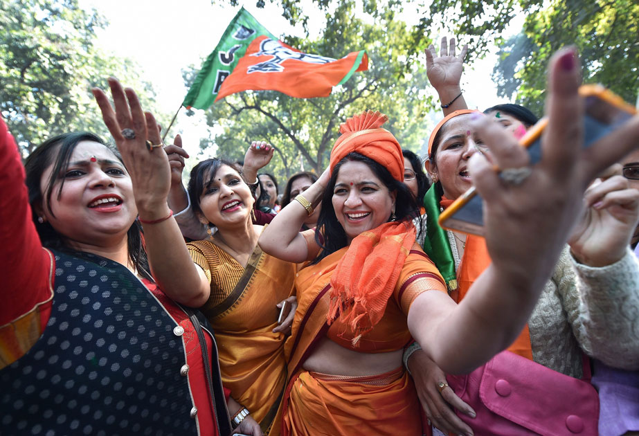 Party workers and supporters celebrating BJP`s success in the Gujarat and Himachal Pradesh state assembly elections, outside the BJP headquarter, in New Delhi.