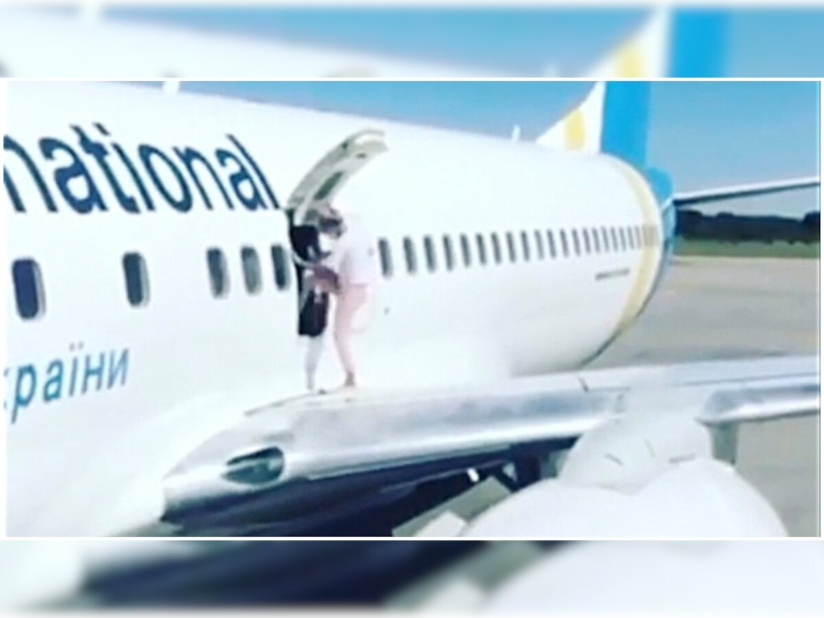 विमानात गरम होत असल्यामुळे महिलेने उघडला इमर्जंसी गेट : viral Video  title=