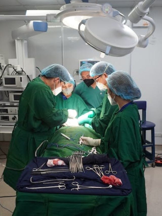 Surgeon Dress Code wearing green and blue clothes