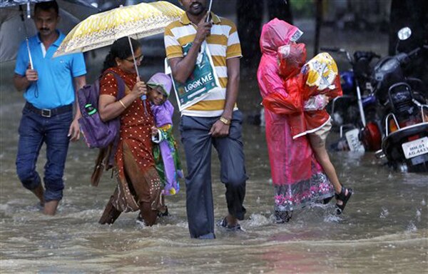 मुंबई पावसाने धुमाकूळ घातल्याने सखल भागात साचलेल्या पाण्यातून वाट काढताना